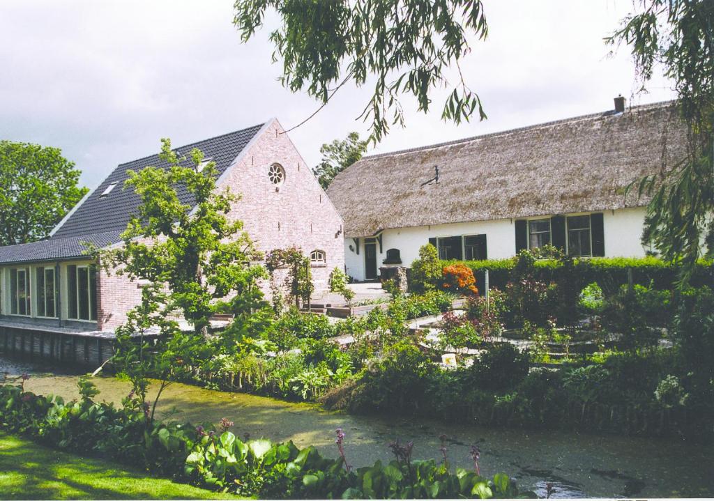 an old stone house with a garden in front of it at de Boomgaard Groene Hart in Polsbroekerdam