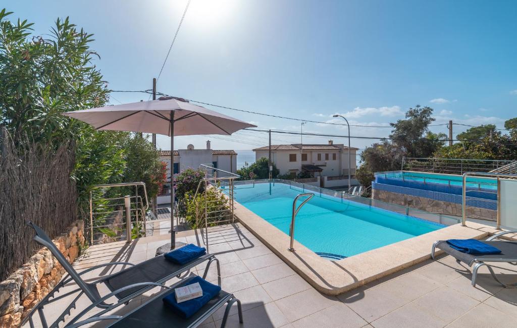 a swimming pool with an umbrella and chairs and a pool at Bellavista 2 sea views in Alcudia