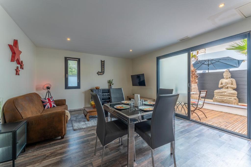 un salon avec une table, des chaises et un canapé dans l'établissement Le Littoral - Piscine et plage aux pieds, au Grau-dʼAgde