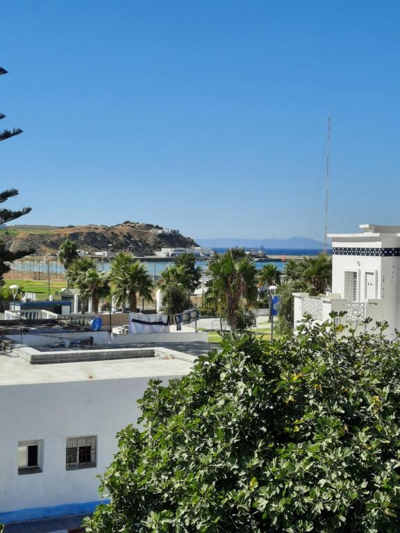 - une vue sur un bâtiment avec un arbre au premier plan dans l'établissement MAISON D HÔTES Marine KSAR SGHIR, à Ksar Sghir