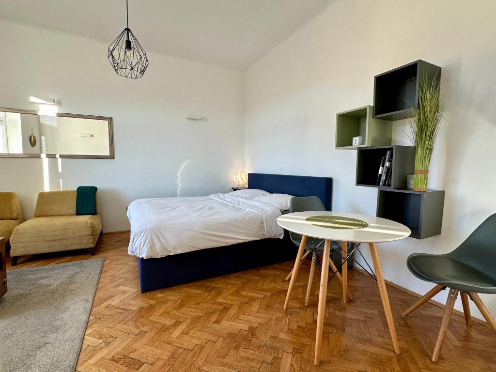 a bedroom with a bed and a table and a couch at Modern studio in the heart of the city in Maribor