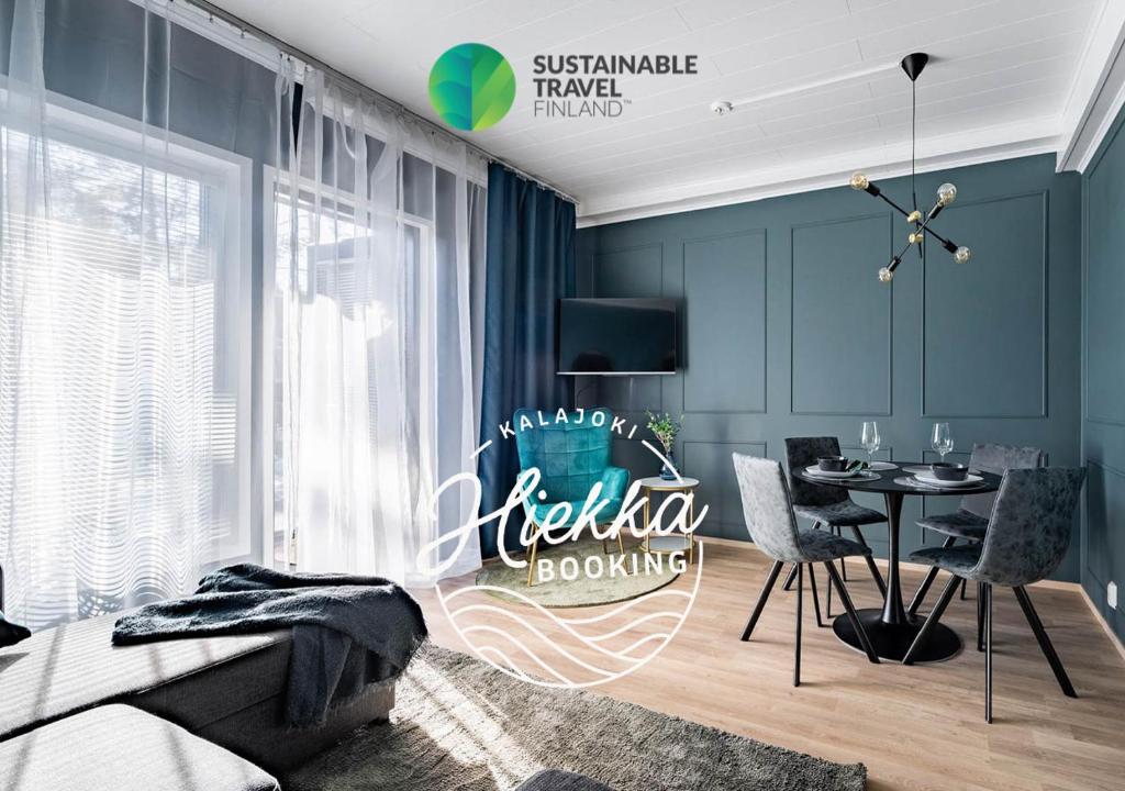 1 dormitorio con paredes azules, mesa y sillas en Hilmantori Apartments by Hiekka Booking, en Kalajoki