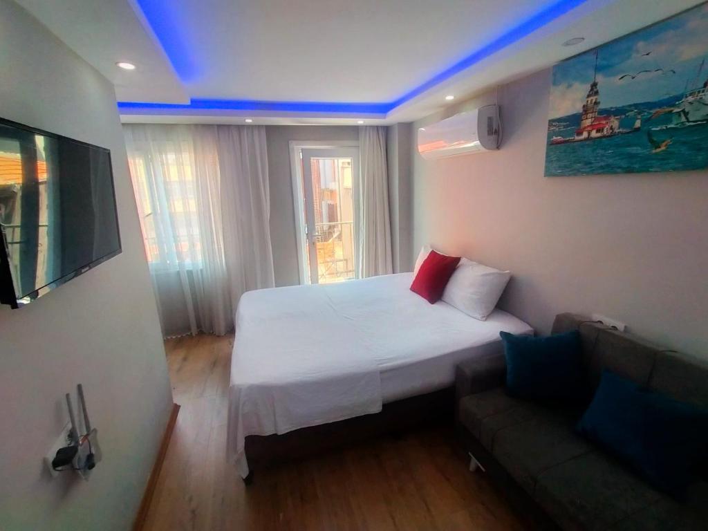 um pequeno quarto com uma cama e um sofá em BlueRoyal Grand Bazaar em Istambul