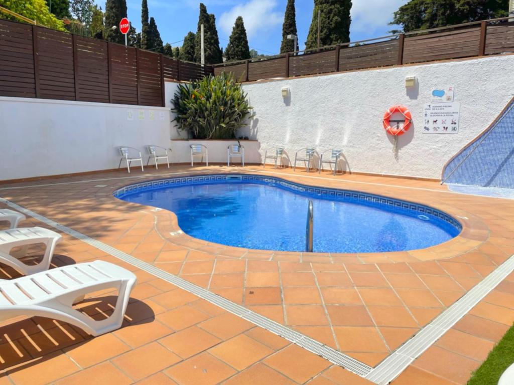 a swimming pool in a patio with chairs around it at Hotel Turissa in Tossa de Mar