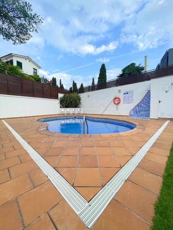a swimming pool on a brick patio at Hotel Turissa in Tossa de Mar