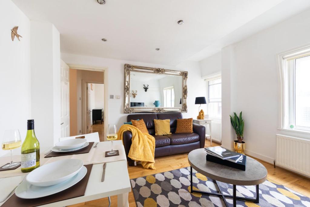 a living room with a couch and a table at Bond Street Apartment - Sleeps 4 in London