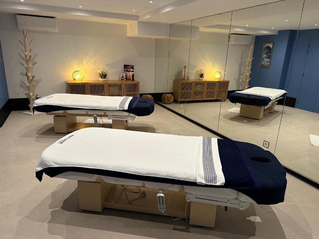 a room with two beds and mirrors in it at Le Manoir De La Poterie & Spa in Cricquebœuf