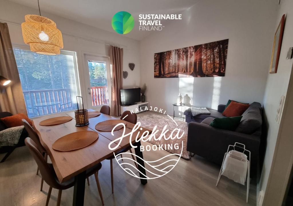ein Wohnzimmer mit einem Tisch und einem Sofa in der Unterkunft SkyVillas Apartments by Hiekka Booking in Kalajoki