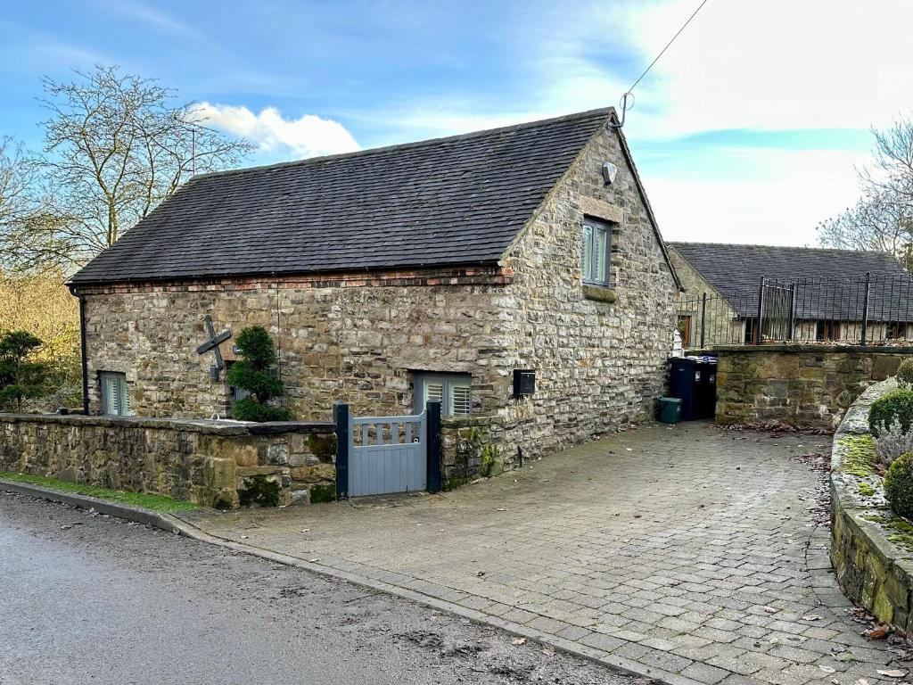 una antigua casa de piedra con puerta y entrada en Lilimae Barn, en Ashbourne