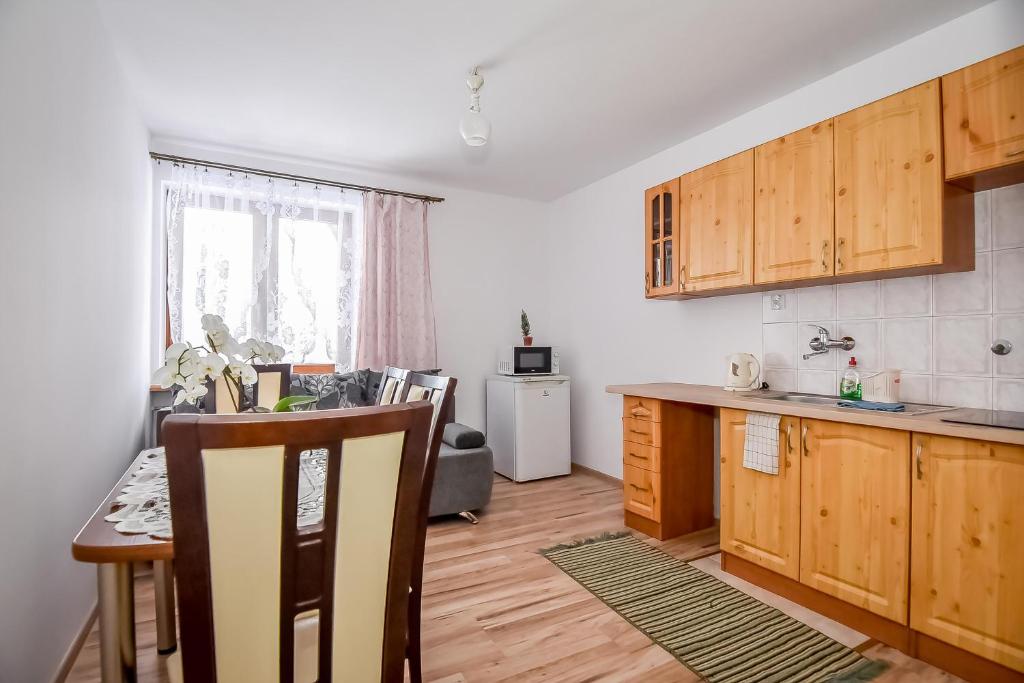 a kitchen with wooden cabinets and a table with a tableablish at Apartamenty u Gabi in Poronin
