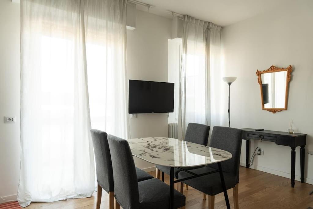 a dining room with a table and chairs and a television at Youhosty - Soderini 25 in Milan