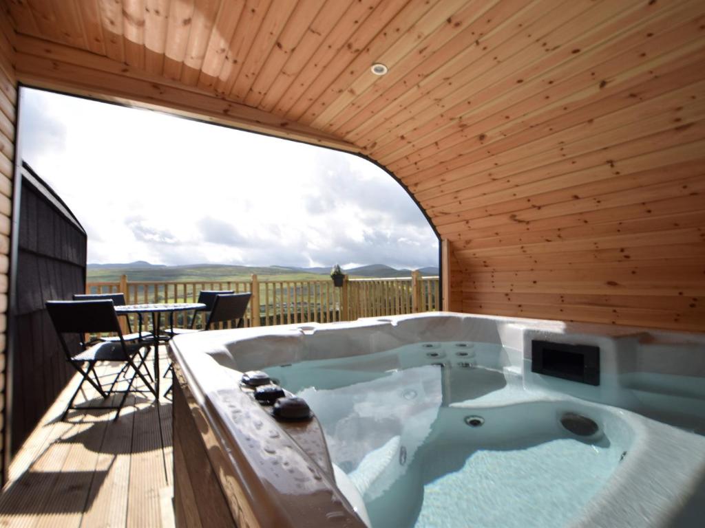 a jacuzzi tub on the deck of a house at 1 Bed in Teviothead 75346 in Hawick