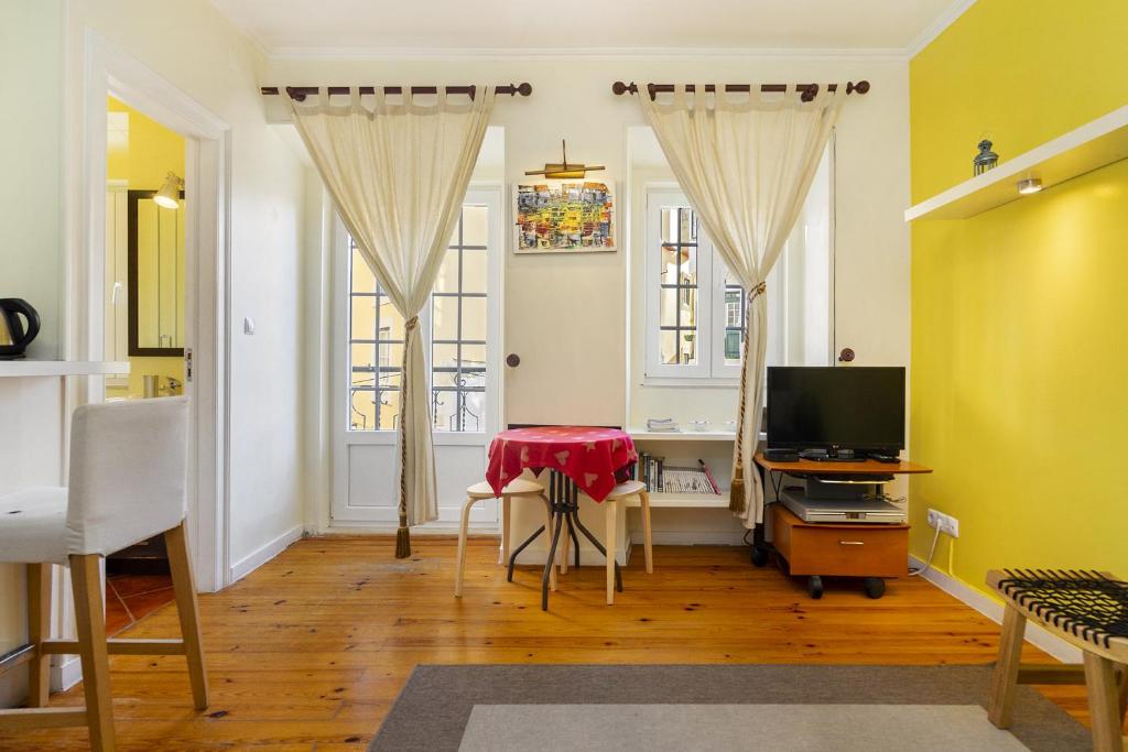 uma sala de estar com uma mesa e uma televisão em WHome Central Alfama Hideaway perfect to explore Lisbon em Lisboa