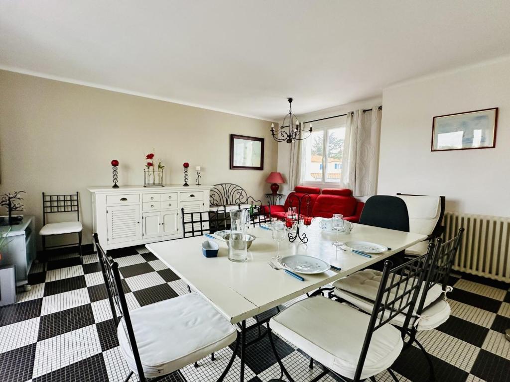 ein Esszimmer mit einem weißen Tisch und Stühlen in der Unterkunft Maison de famille au calme quartier de la Marcelliere in Les Sables-dʼOlonne