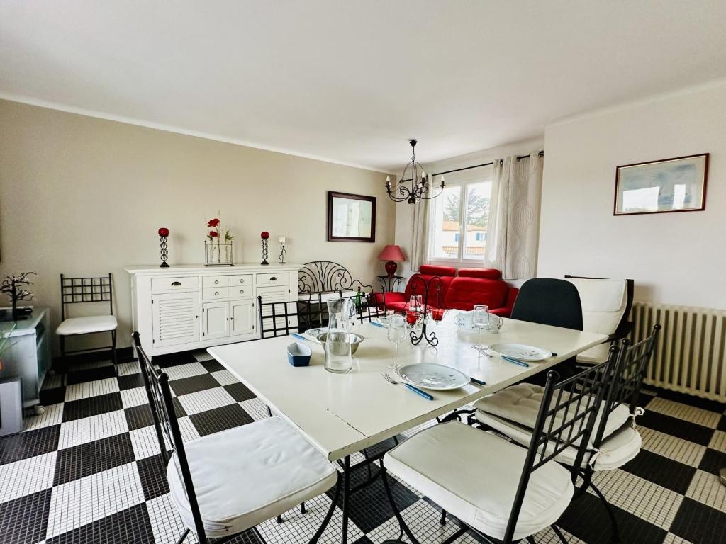 une salle à manger avec une table et des chaises blanches dans l'établissement Maison de famille au calme quartier de la Marcelliere, à Les Sables-dʼOlonne