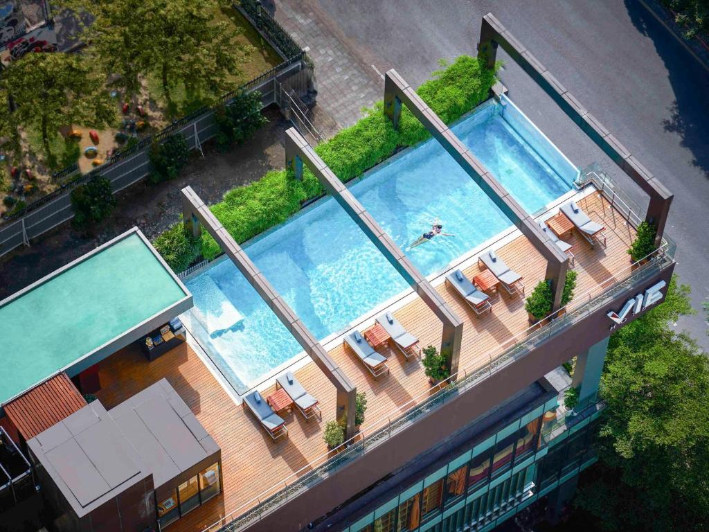 an overhead view of a swimming pool with lounge chairs and a pool at VIE Hotel Bangkok, MGallery in Bangkok