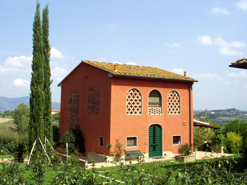 a small orange building with a green door at Il Cigliere your holiday home in the heart of Tuscany in Florence