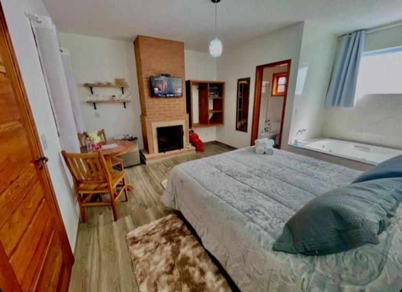 sypialnia z dużym łóżkiem i kominkiem w obiekcie Refugio Victoria w mieście Monte Verde