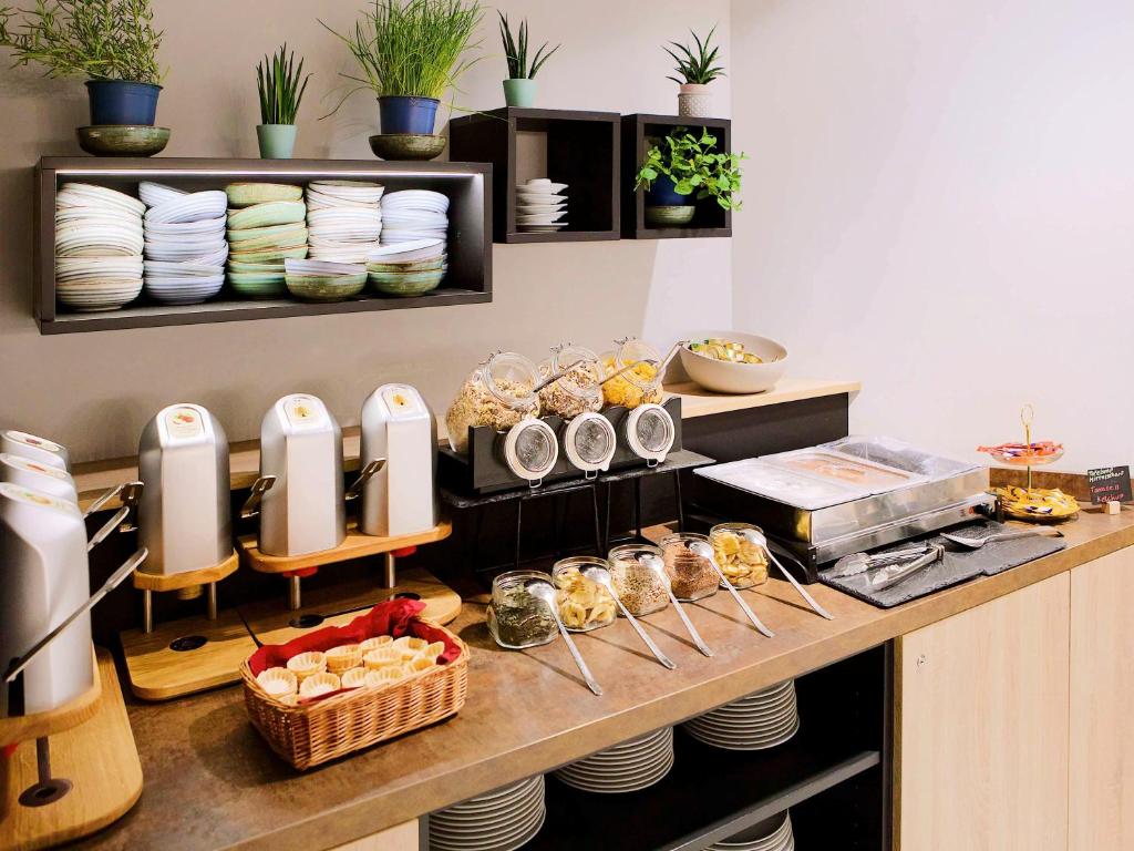 - une cuisine avec un comptoir avec des assiettes et de la vaisselle dans l'établissement Aparthotel Adagio Access Freiburg, à Fribourg-en-Brisgau