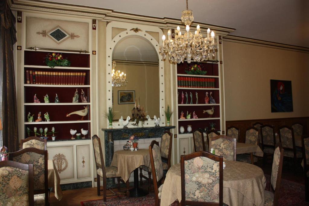 uma sala de jantar com uma mesa e cadeiras e um lustre em Alliance Hotel Ieper Centrum em Ypres