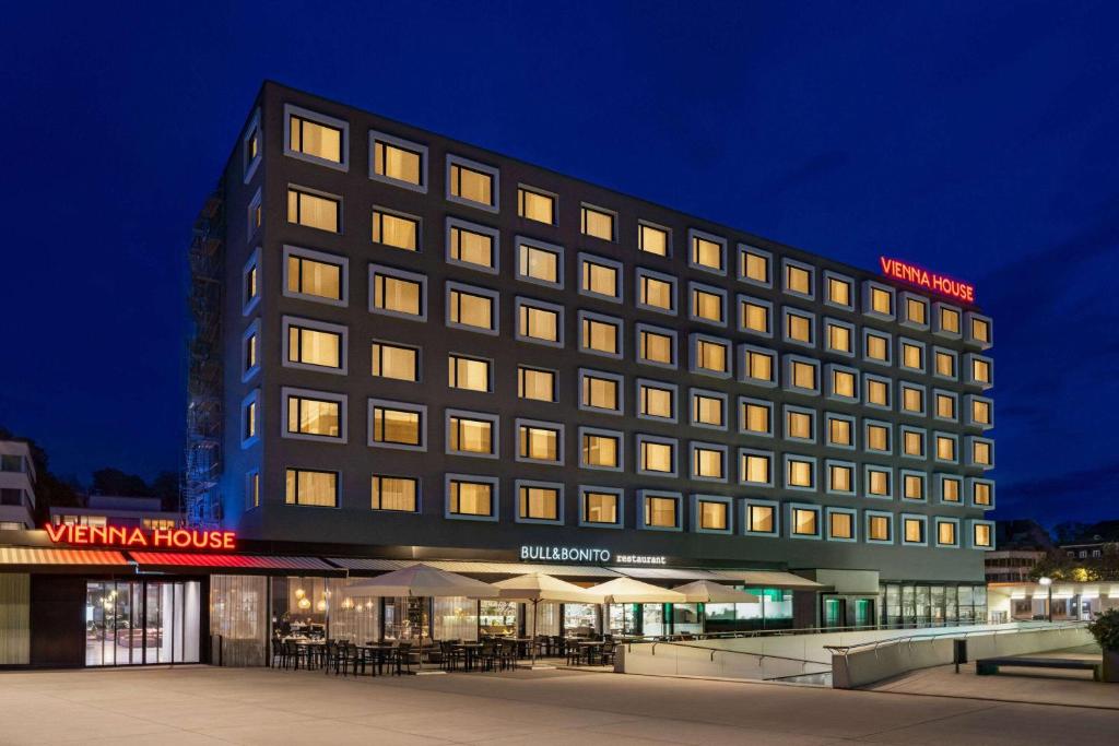 een hotelgebouw met veel ramen 's nachts bij Vienna House by Wyndham zur Bleiche Schaffhausen in Schaffhausen