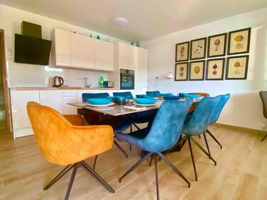 uma cozinha com uma mesa de jantar e cadeiras azuis em Harbour View House em Zaton