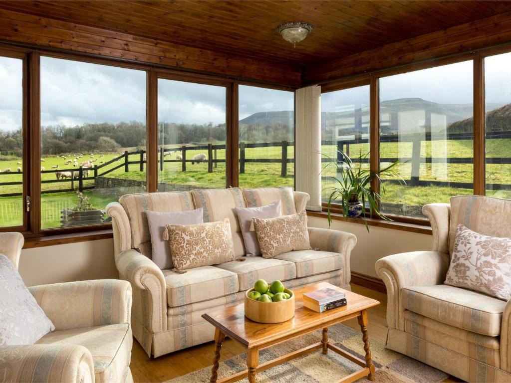 un soggiorno con divani, tavolo e finestre di 3 Bed in Brecon Town BN037 a Llanspyddid