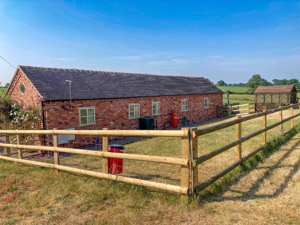 a barn with a wooden fence in front of it at 2 Bed in Audlem 81106 in Audlem