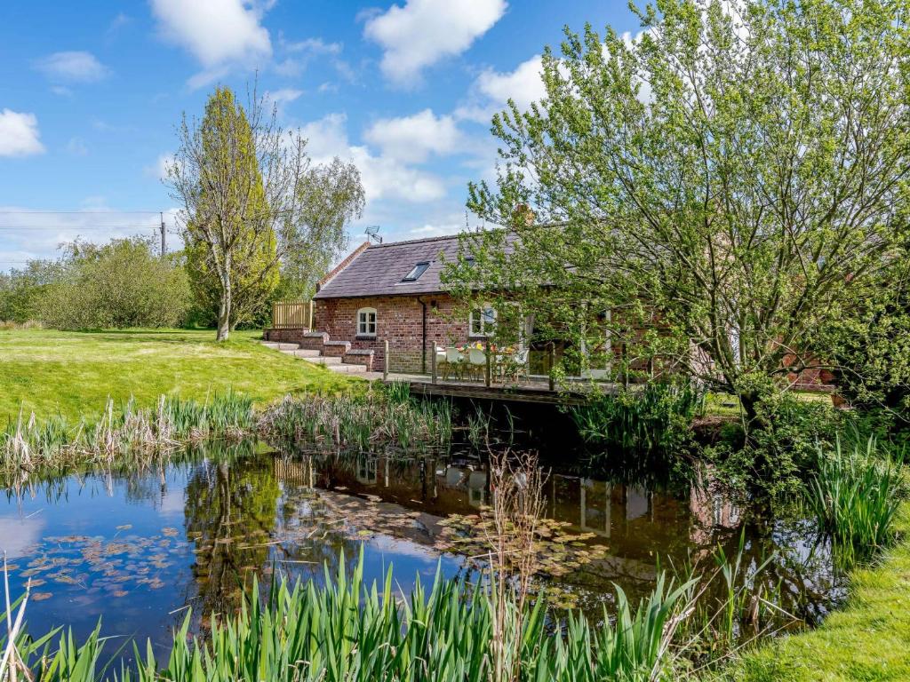 a house with a bridge over a pond at 3 Bed in Chester 82909 in Ledsham