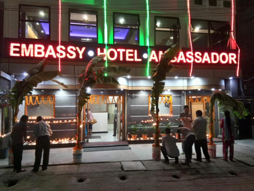 a group of people standing outside of a hotel at night at Ambassador Hotel in Guwahati