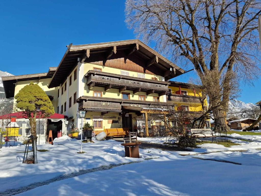 un gran edificio en la nieve con suelo cubierto de nieve en Ferienhotel Lindenhof, en Leogang