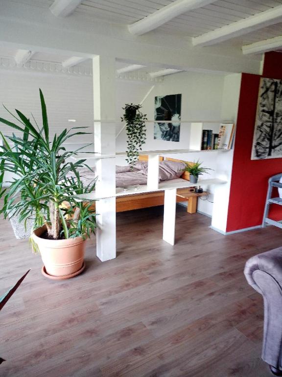 a living room with a bench and potted plants at Ferienwohnung Pullinger Fliegenfischerschule in Blaibach