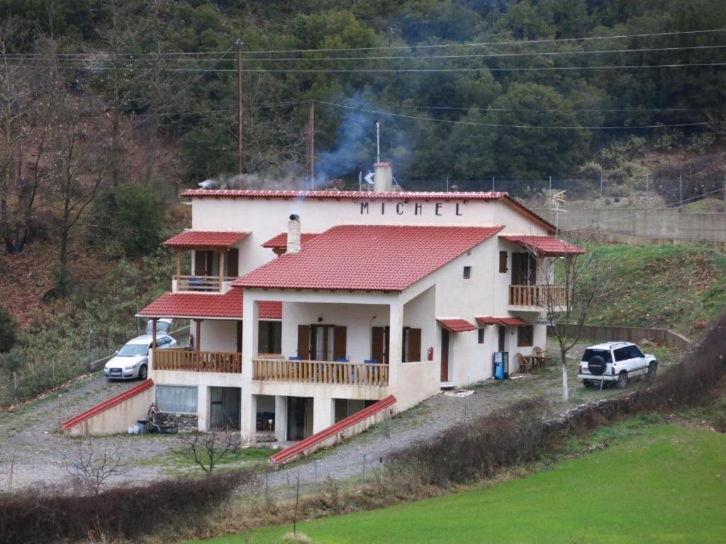 une maison sur une colline avec deux voitures garées devant dans l'établissement Michel Studios, à Kalavrita