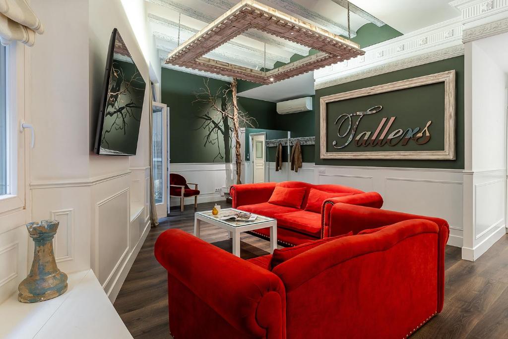 バルセロナにあるEnjoybcn Tallers Apartmentのリビングルーム(赤い椅子2脚、テーブル付)