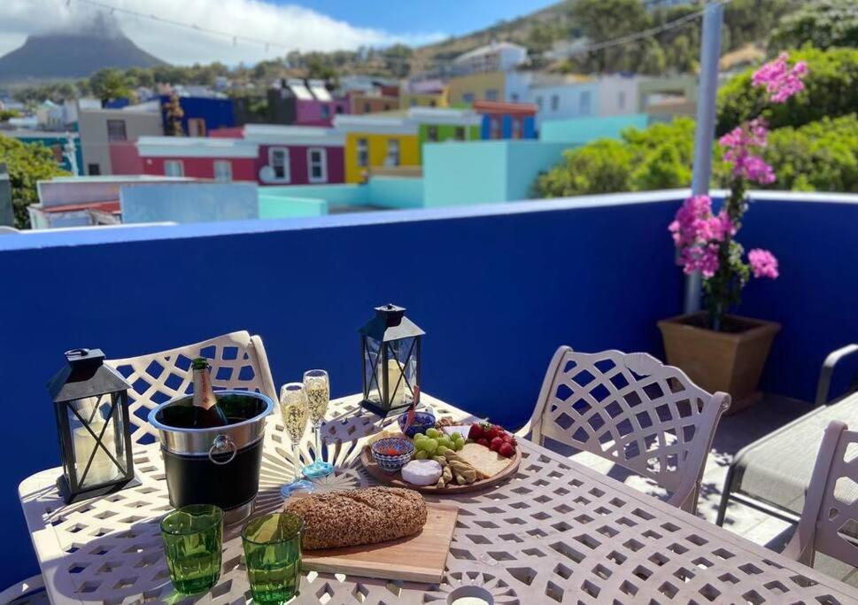 Una mesa con un plato de comida en un balcón. en Modern city townhouse with rooftop terrace, en Ciudad del Cabo