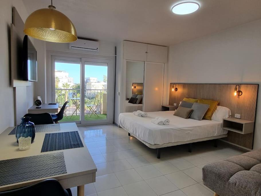 a bedroom with a large bed and a living room at Jupiter2 Moderno estudio Parque La Paloma in Benalmádena