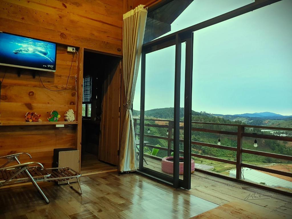 a living room with a large sliding glass door with a view at Tuyên Chiến Home - Nhà Gỗ in Ấp An Kroët