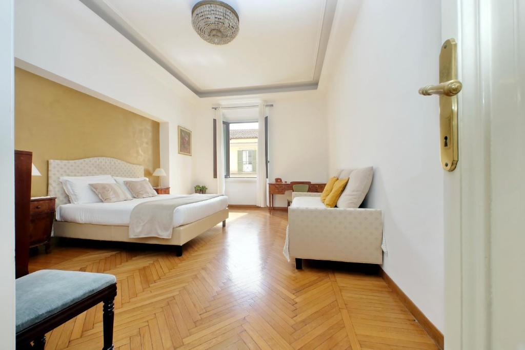 - une chambre avec un lit, un canapé et une chaise dans l'établissement Spanish Steps Family Home by TreasureRome, à Rome