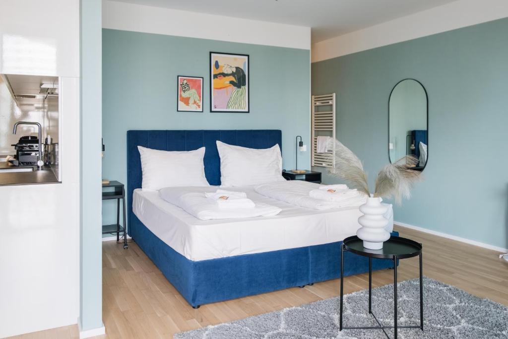um quarto azul e branco com uma cama e uma mesa em Decorous cozy city view suite em Viena