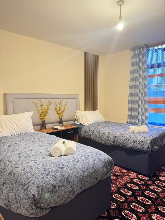 twee bedden in een hotelkamer met handdoeken erop bij Flat 71 in Bristol