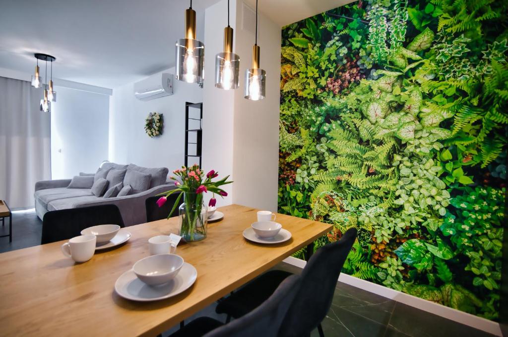uma sala de jantar com uma grande pintura na parede em Apartamenty Laguna Beskidów - A33 em Zarzecze