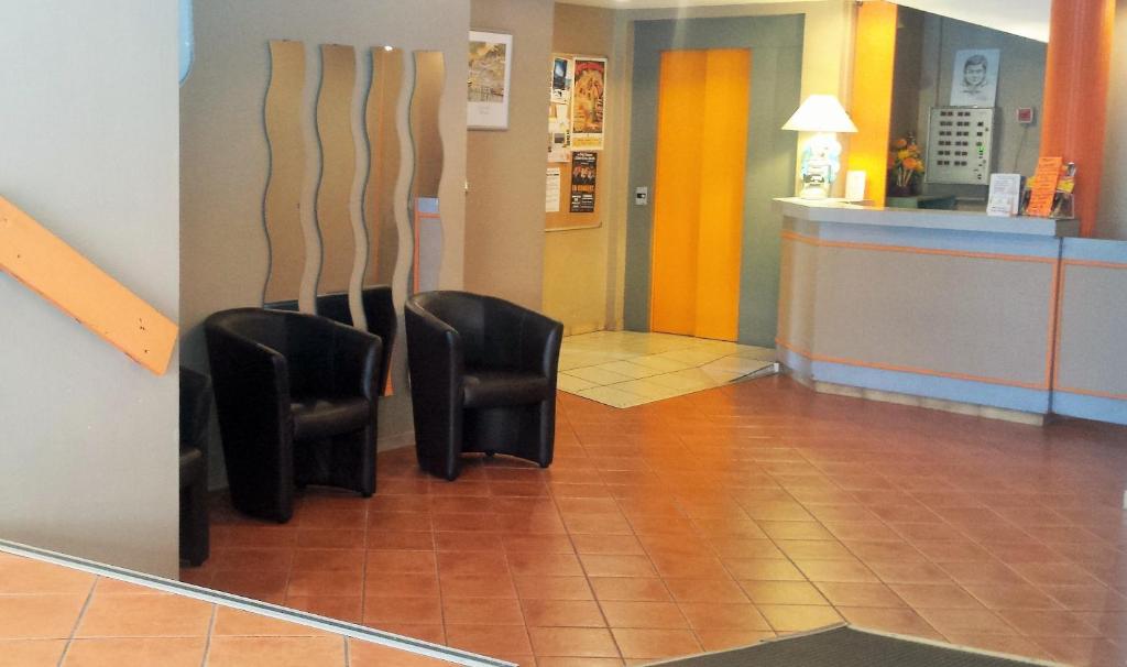 two black chairs sitting in a waiting room at Hôtel du Château Fort in Lourdes