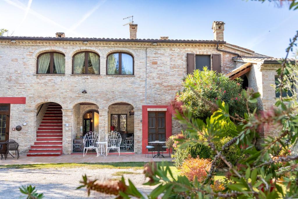 a brick house with a patio in front of it at Agriturismo Corte Decia in Saludecio