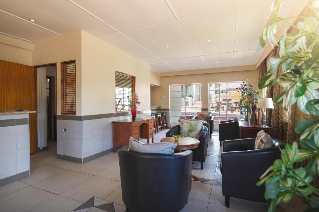 a living room with couches and a table at Oak lodge Guest House in Grahamstown