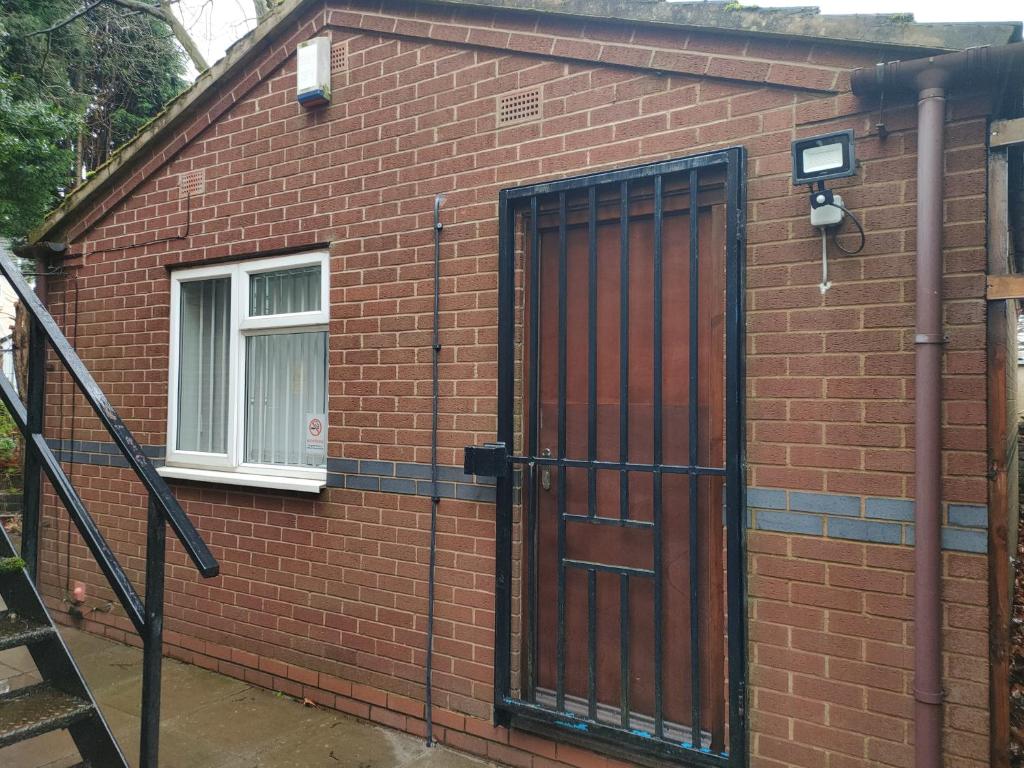 a red brick building with a door and a window at Local to Russells Hall Hospital in Brierley Hill