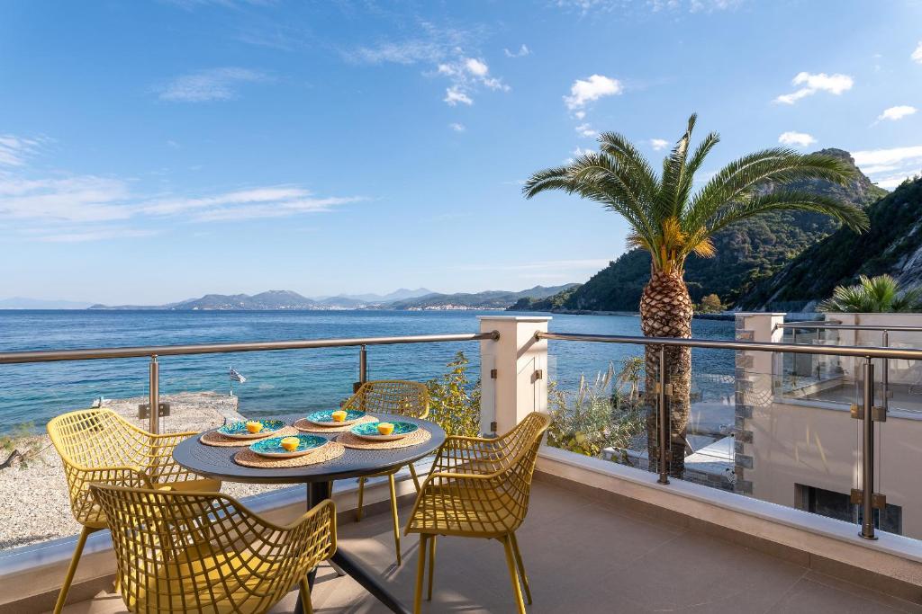 d'un balcon avec une table et des chaises et une vue sur l'océan. dans l'établissement 8MOONS Elegant Apartments, à Kokkari