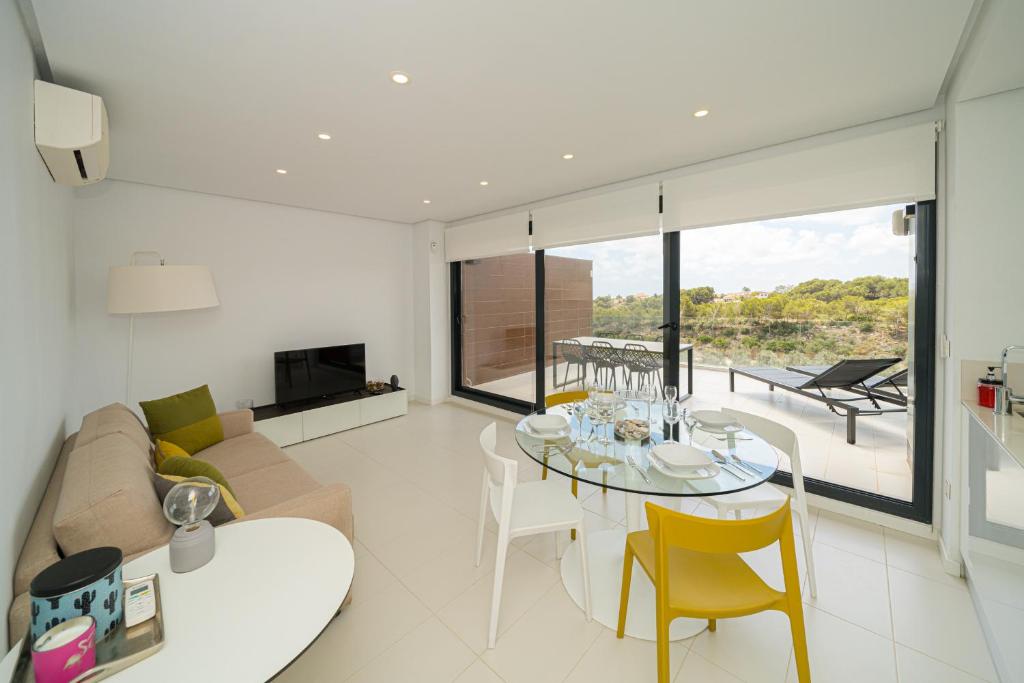 ein Wohnzimmer mit einer Couch und einem Tisch und Stühlen in der Unterkunft Bonifacio in Villacosta