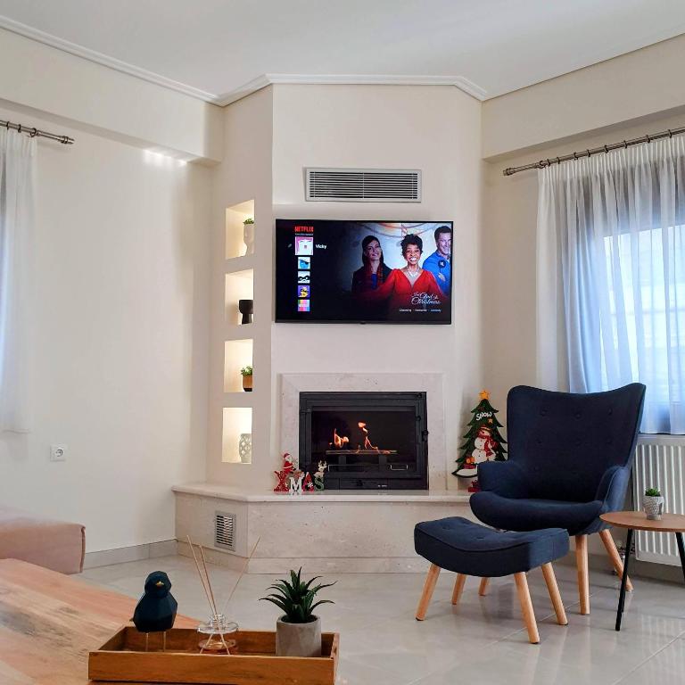 a living room with a fireplace with a flat screen tv at Volos Park Apartments in Volos