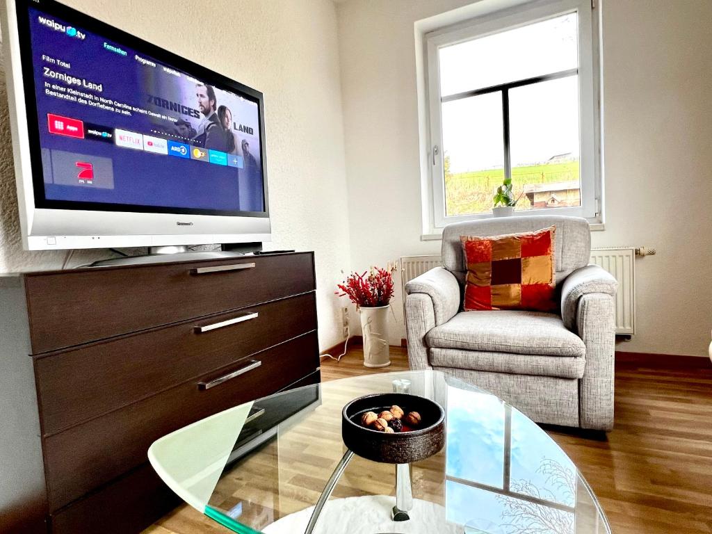 a living room with a tv and a coffee table at Göltzschtal Apartment in Mylau