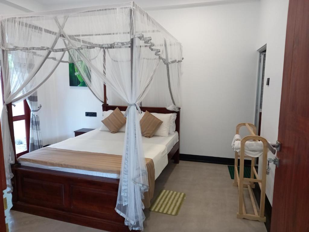 una camera con letto a baldacchino di The Mango House Ahangama ad Ahangama